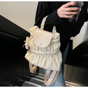 Detail of cream pleated nylon backpack with leather flap and mini matching pouch