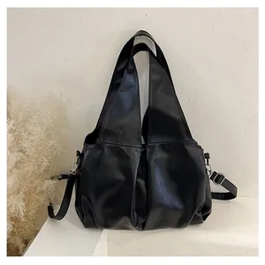Vue détaillée du grand sac cabas noir avec texture cuir souple et garnitures argentées