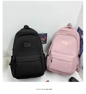 Dual view of black and pink lightweight nylon backpacks with front zip pockets