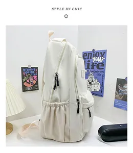 Detail view of cream nylon backpack featuring a functional side pocket and front zipper pocket