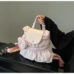 Detail of light pink pleated nylon backpack with ivory leather flap and small bow pouch