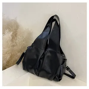 Gros plan sur un sac cabas plissé noir avec détails argentés et texture en cuir mat doux