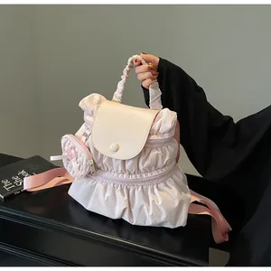 Detailed view of pink pleated nylon backpack with ivory leather flap and cloud-like handle