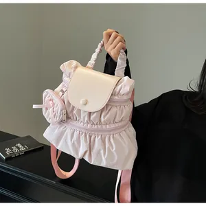 Close-up of pink nylon backpack with ruffle details and decorative side bow accessory