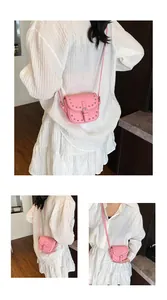 Detail view of pink mini saddle bag with silver rivet studs and adjustable strap