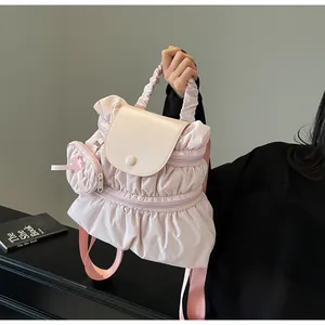 Detail of pink ruffled nylon backpack with beige leather flap and matching bow coin purse