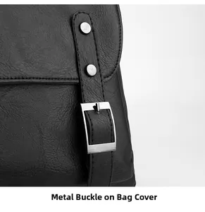 Detailed close-up of the black leather backpack flap with silver metal buckle hardware