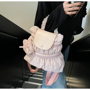 Pink pleated nylon backpack featuring a mini bow charm and smooth flap closure details