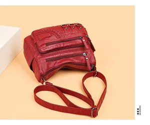 Dettaglio borsa a tracolla rossa in pelle PU lavata con tasche multiple a zip