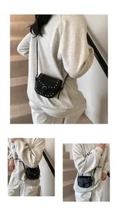 Detail view of mini saddle bag with silver studs and adjustable strap worn by model