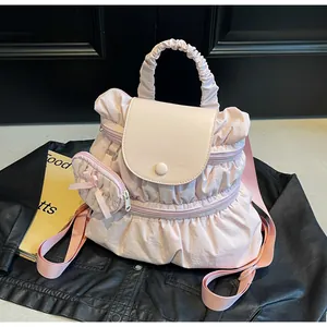 Detailed shot of pink pleated backpack with matching bow mini pouch and smooth leather flap