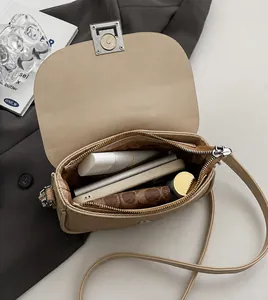 Interior view showing the large capacity of the beige saddle bag with metal zipper
