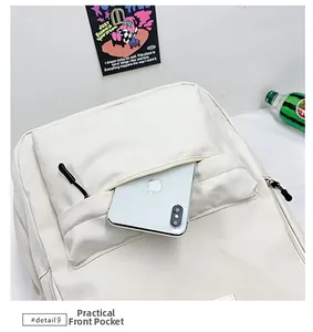 Practical front pocket of white backpack showing capacity for a large smartphone