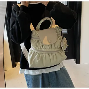 Detailed view of cream nylon backpack featuring pleated textures and a mini storage pouch