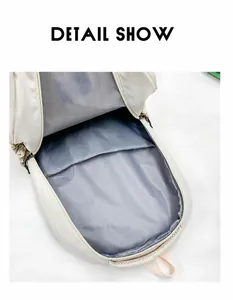 Detail view of the spacious main compartment with grey lining in a cream backpack