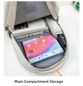 Internal view of cream backpack showing main compartment storage for laptop and books