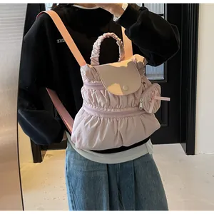 Pink pleated nylon mini backpack with detachable coin purse shown in a lifestyle mirror selfie