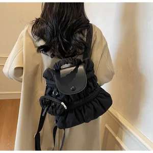 Detail of the pleated nylon fabric and smooth leather flap on this stylish black backpack