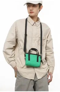 Asian male model wearing a lime green canvas mini tote bag with black shoulder straps