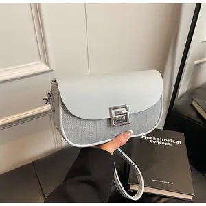 Detail of light blue saddle bag featuring woven texture and silver geometric buckle