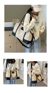 Detail of canvas travel bag with black leather stitching and adjustable shoulder strap