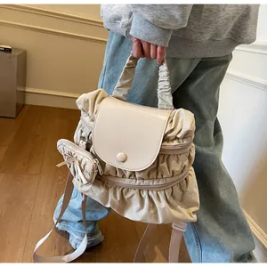 Detail of beige pleated nylon backpack featuring a mini pouch and ruffled fabric design