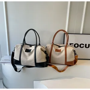 Detail of canvas travel bags with leather straps and detachable shoulder straps in two colors