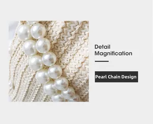 Detail of the woven straw beach bag featuring a luxurious white pearl chain strap design