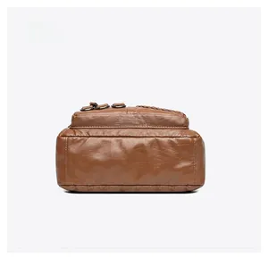 Dettaglio del fondo rinforzato e della texture cerata della borsa a tracolla marrone