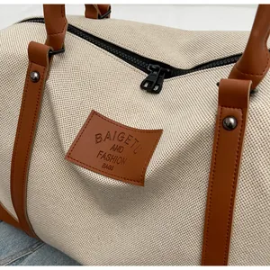 Close-up of canvas texture and brown leather handle on large weekend travel bag