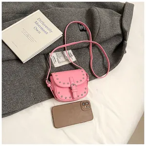 Pink mini rivet saddle bag shown next to a smartphone to demonstrate portable compact size