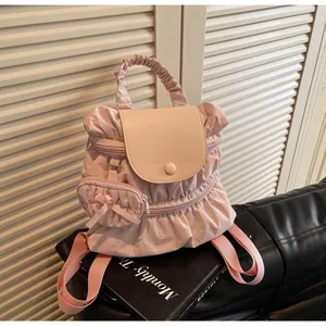 Close-up of pink pleated nylon backpack showing cloud handle and ribbon charm detail