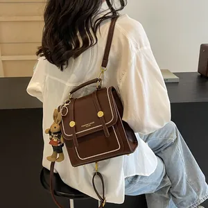 Mochila vintage de cuero marrón con colgante de conejo mostrada por una modelo