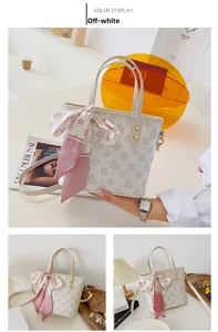 Detailansicht der cremefarbenen Mini-Tote-Bag mit Kunstmuster, Seidentuch und Goldbeschlag