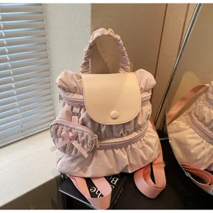 Detail view of pink pleated nylon backpack with a heart pendant and ribbon bow decoration