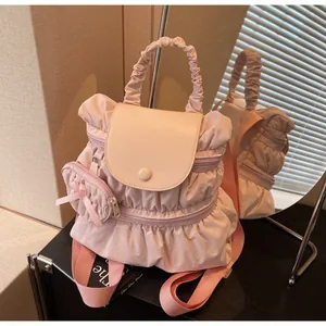Detail of pink pleated nylon backpack with ruffled edges and cute round coin purse charm