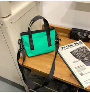 Macro detail of a bright green nylon crossbody bag on a wooden table with accessories