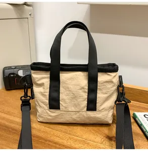 Detailed view of lightweight nylon crossbody bag featuring contrast trim and top handle