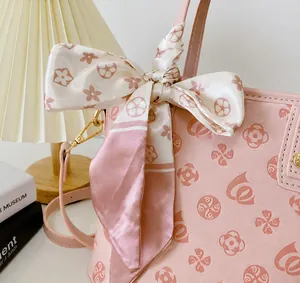 Detail der rosa Mini-Tasche mit Seidenschal-Schleife und goldfarbenem Hardware-Haken
