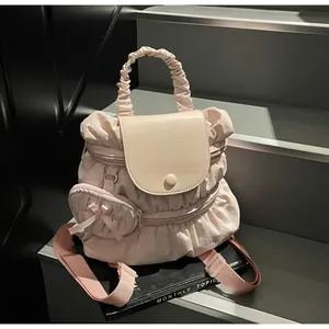 Close-up of pink pleated nylon backpack with ruffled mini pouch and top handle