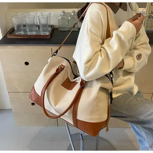Detail of canvas travel tote with premium leather trim and large interior capacity