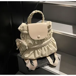 Detail of off-white nylon backpack showing pleated texture and matching mini pouch