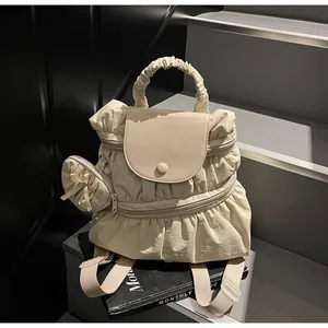 Detail of ruffled nylon backpack in cream beige with a matching mini round coin pouch