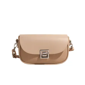 Minimalist beige and khaki patchwork saddle bag with silver buckle and leather strap