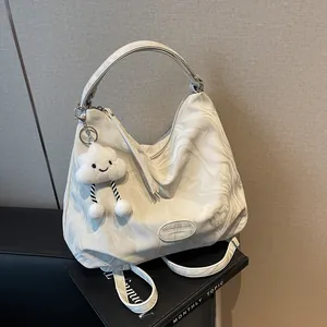 Détail du sac cabas à motif marbré avec logo Muon Shark et porte-clés nuage en peluche