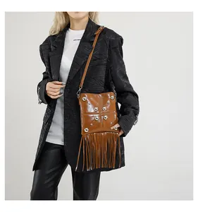 Dettaglio borsa a tracolla in pelle marrone con borchie argentate e lunghe frange