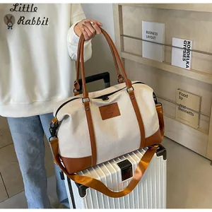 Detailed close-up of a large canvas travel bag attached to a suitcase handle bar