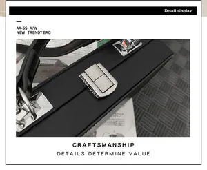 Detailed view of silver metal latch lock and textured black leather hard-shell box bag