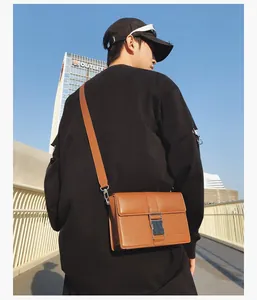 Brown leather crossbody bag detail featuring a silver metal buckle closure on the flap