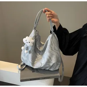 Détail du grand sac cabas motif marbre avec breloque nuage et logo sur le devant